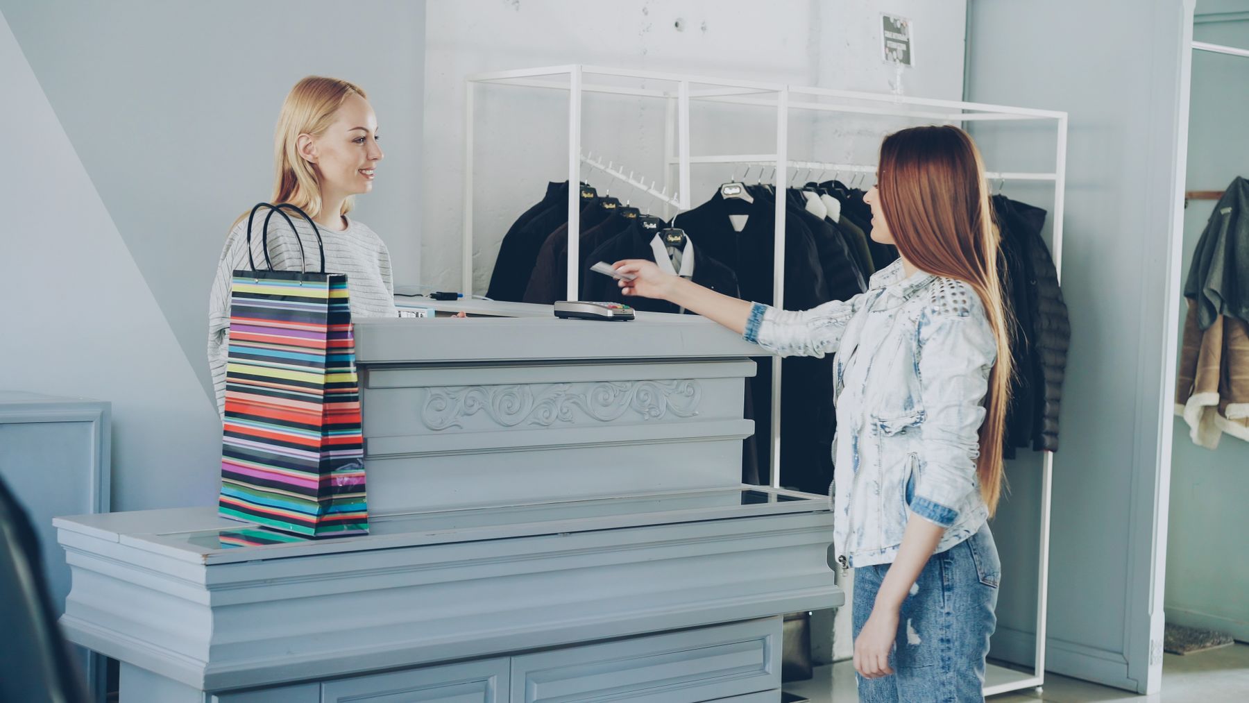 A customer paying by card at a shop counter.